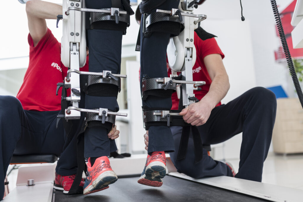 Patient is being placed in an assitive device for walking